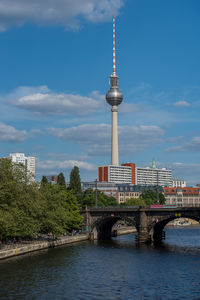 Fernsehturm in city against blue sky