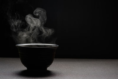 Close-up of coffee cup against black background