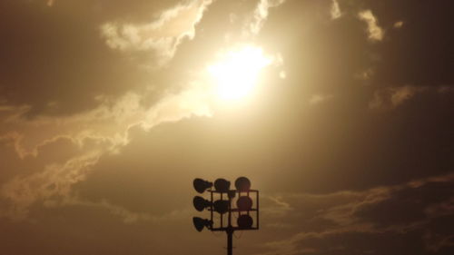 Low angle view of silhouette sign against sky during sunset