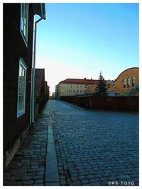 Empty alley amidst buildings in city