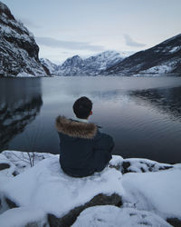 Rear view of man on snowcapped mountains during winter