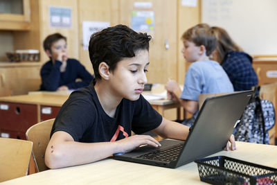 Boy using laptops at school