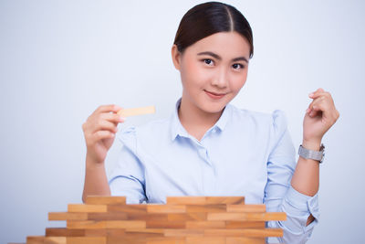 Portrait of smiling young woman against white background