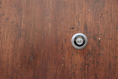 Close-up of peephole on wooden door