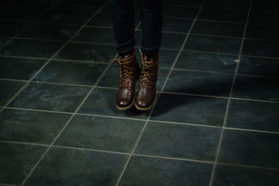 Low section of man standing on tiled floor