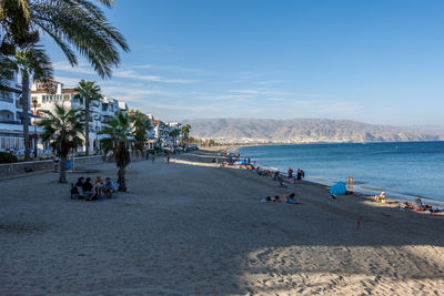 People on beach by sea against sky