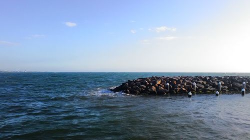 Scenic view of calm sea against cloudy sky