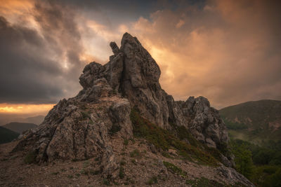 Low angle view of rock formation against sky during sunset