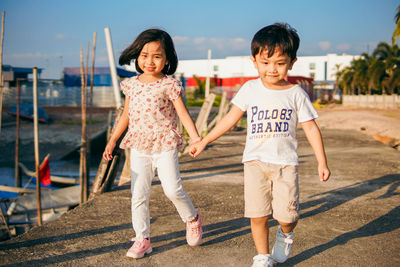 Full length of a siblings standing outdoors