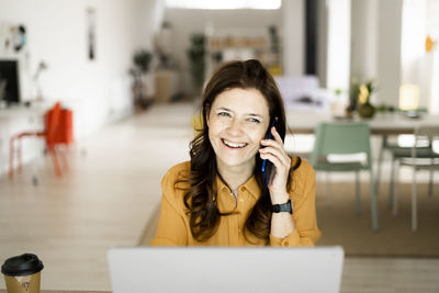 Portrait of smiling young woman using smart phone
