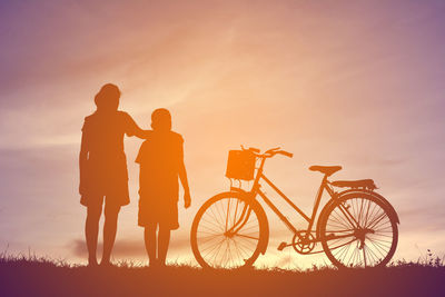 Silhouette of friends against sky during sunset