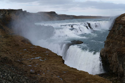 Scenic view of waterfall against sky