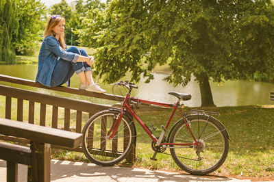 Young pretty woman have a rest in a park after bike ride. outdoor relaxing