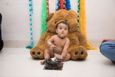 Portrait of cute boy toys on floor at home