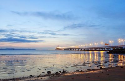 View of bridge over sea against cloudy sky