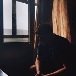Man sitting in window at home