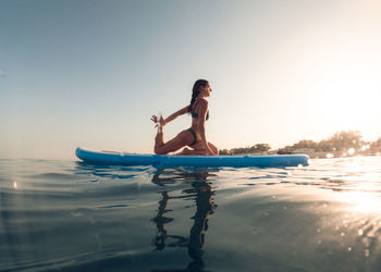 Rear view of woman standing in sea