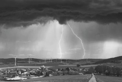 Panoramic view of lightning over sea against storm clouds