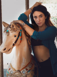 Portrait of beautiful young woman standing by sculpture