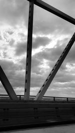 Low angle view of bridge against cloudy sky