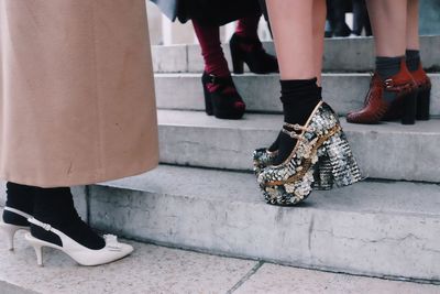 Low section of women wearing high heels on steps