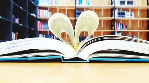 Open book on table in library