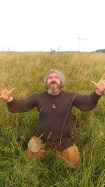 Portrait of man with arms raised on field