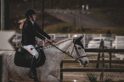 Side view of woman riding horse