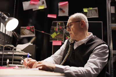 Side view of man working at table