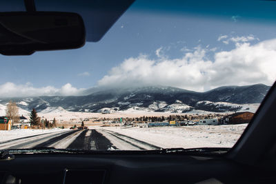 Snowy scenic view of mountains from inside the car