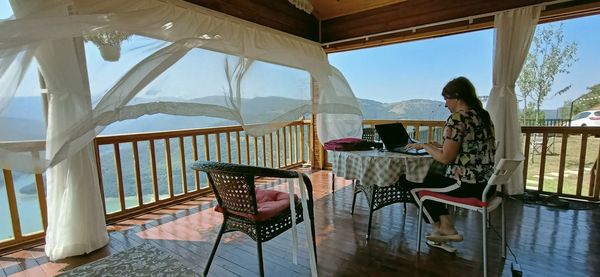 Woman sitting on table in balcony