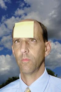 Close-up portrait of young man against sky