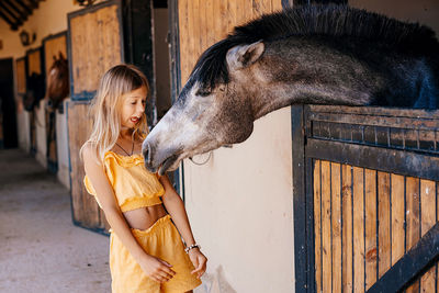 Girl on a ranch communicates with horses. horses in the stable