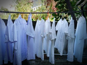 Clothes drying on clothesline against white background