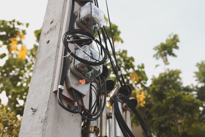 Low angle view of electric lamp hanging on pole