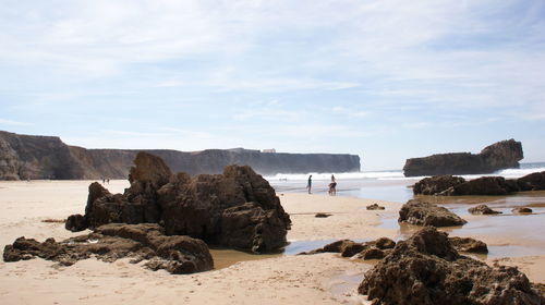 Rocks at beach against sky