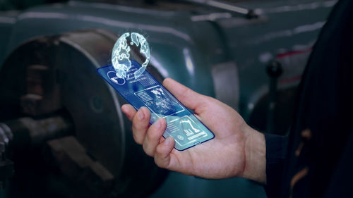 Close-up of hand holding mobile phone in car