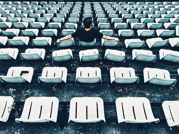 Full length of man sitting on bleacher in stadium