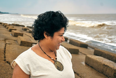 Woman looking at sea while standing against sky