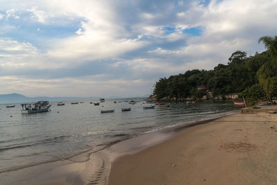 Scenic view of beach against cloudy sky