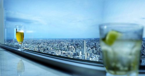 Close-up of beer in glass against cityscape