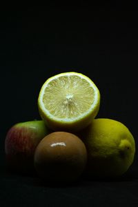 Close-up of fruits on table against black background