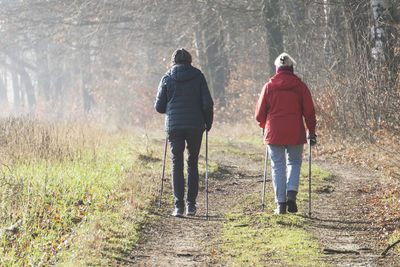 Rear view of two women practicing nordic walking