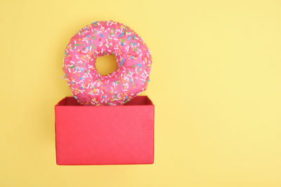 Close-up of multi colored candies against yellow background