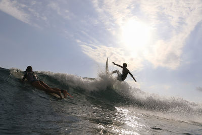 Surfer on a wave at sunset time