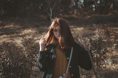 Portrait of beautiful young woman standing in forest