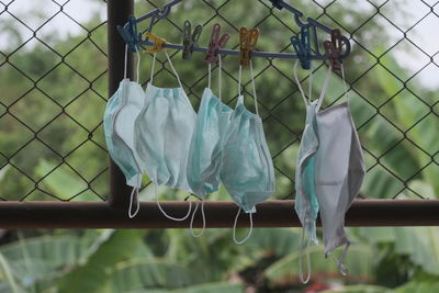 Close-up of clothes drying on clothesline against fence
