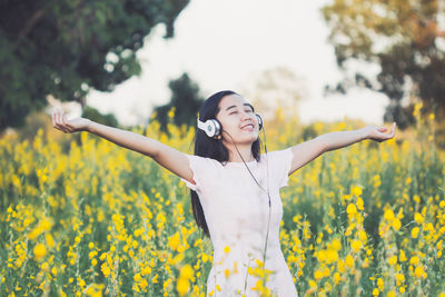 Full length of woman with arms raised on field