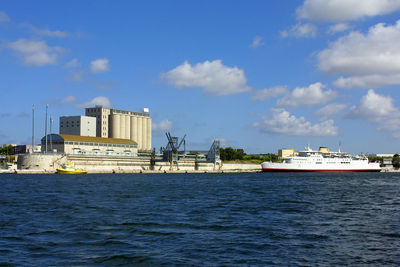 Boats in sea against sky in city