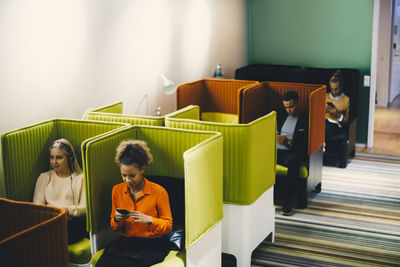 High angle view of multi-ethnic business colleagues sitting on chairs at office